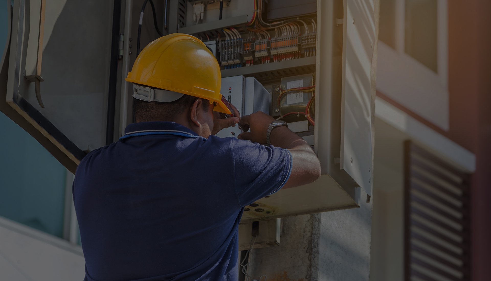 Utility worker in a hard hat inspecting electrical equipment