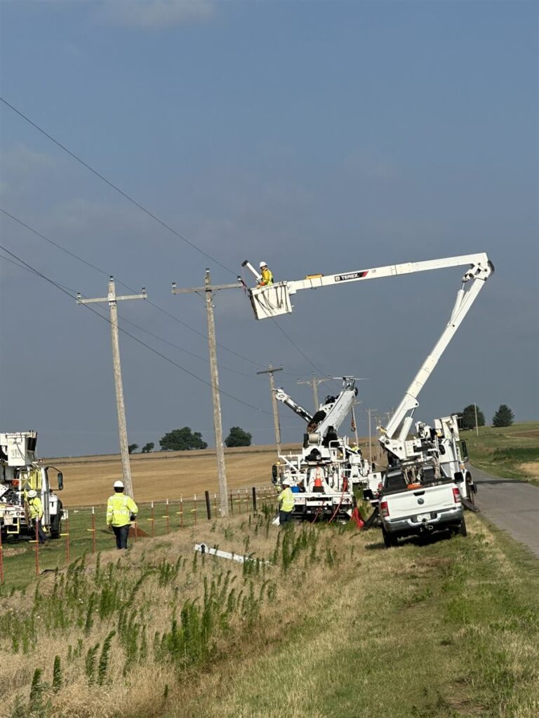 Bucket trucks and crew on a rural Texas road during line construction