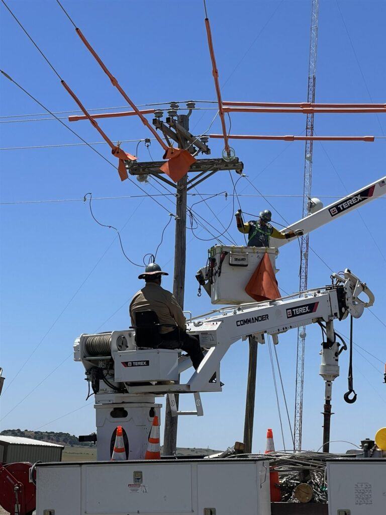 Linemen working from bucket trucks during distribution construction